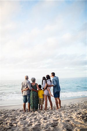 Cute family facing the sea on the beach Photographie de stock - Premium Libres de Droits, Code: 6109-08434885