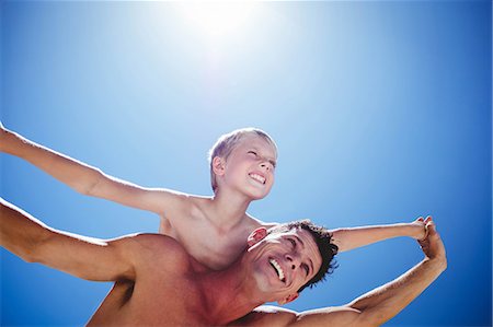 simsearch:6109-08434724,k - Father giving piggy back to his son on the beach Photographie de stock - Premium Libres de Droits, Code: 6109-08434800