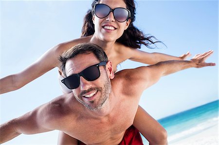 simsearch:6109-06781582,k - Boyfriend giving piggy back to his girlfriend on the beach Stock Photo - Premium Royalty-Free, Code: 6109-08434804