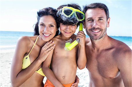 simsearch:6109-08434812,k - Cute boy wearing snorkeling equipment with his parents on the beach Foto de stock - Royalty Free Premium, Número: 6109-08434818