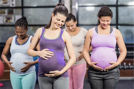 pregnant black women white man - Smiling pregnant women touching their belly at the leisure center Stock Photo - Premium Royalty-Free, Code: 6109-08434955