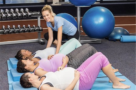 simsearch:6109-08398523,k - Fitness trainer helping pregnant women train at the leisure center Foto de stock - Sin royalties Premium, Código: 6109-08434939