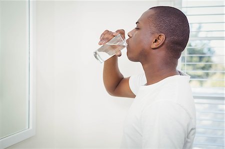 Handsome man drinking water in the bathroom Stock Photo - Premium Royalty-Free, Code: 6109-08435198