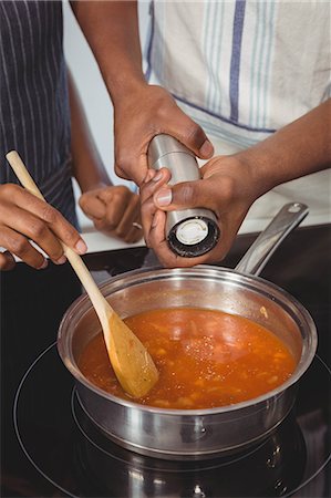 simsearch:6109-08488688,k - Ethnic couple cooking in the kitchen Stock Photo - Premium Royalty-Free, Code: 6109-08435393