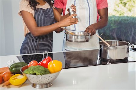 simsearch:6109-08488688,k - Ethnic couple cooking in the kitchen Photographie de stock - Premium Libres de Droits, Code: 6109-08435395