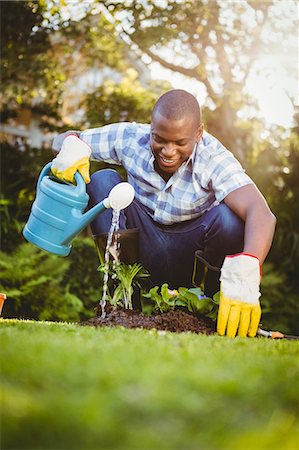 simsearch:6109-08435446,k - Handsome man watering plants in the garden Stock Photo - Premium Royalty-Free, Code: 6109-08435442