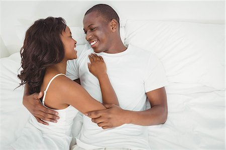 simsearch:6109-08435318,k - Ethnic couple cuddling in bed Stock Photo - Premium Royalty-Free, Code: 6109-08435463