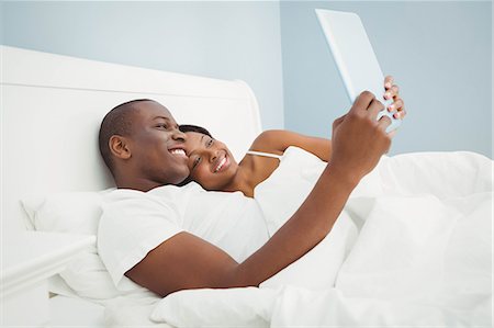 simsearch:6109-07497402,k - Ethnic couple using tablet in the bed Foto de stock - Sin royalties Premium, Código: 6109-08435503