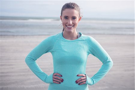 simsearch:6109-08435603,k - Fit brunette wearing sportswear with hands on hips at the beach Stock Photo - Premium Royalty-Free, Code: 6109-08435623