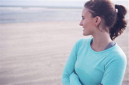 simsearch:6109-08435603,k - Fit brunette wearing sportswear with crossed arms at the beach Stock Photo - Premium Royalty-Free, Code: 6109-08435624