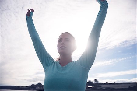 simsearch:6109-08435603,k - Fit brunette raising her arms at the beach Stock Photo - Premium Royalty-Free, Code: 6109-08435625