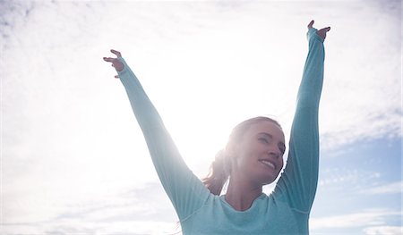 simsearch:6109-08435603,k - Happy fit brunette raising her arms at the beach Stock Photo - Premium Royalty-Free, Code: 6109-08435626