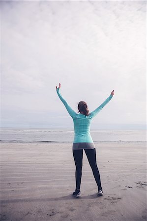 simsearch:6109-08435603,k - Fit brunette raising her arms at the beach Stock Photo - Premium Royalty-Free, Code: 6109-08435628