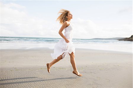 simsearch:6109-08435738,k - Beautiful blonde woman skipping in the coastline Photographie de stock - Premium Libres de Droits, Code: 6109-08435740