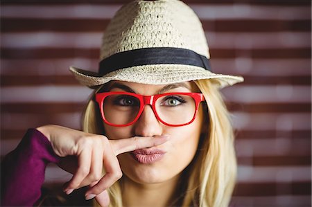 schick - Blonde woman having a fake mustache on brick wall Stockbilder - Premium RF Lizenzfrei, Bildnummer: 6109-08435772