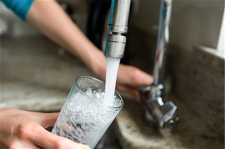 fill glass with water - Pretty blonde woman filling a glass of water at home Stock Photo - Premium Royalty-Free, Code: 6109-08435701