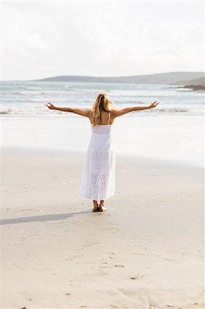 simsearch:6109-08435738,k - Beautiful blonde woman with arms outstretched in the coastline Photographie de stock - Premium Libres de Droits, Code: 6109-08435737