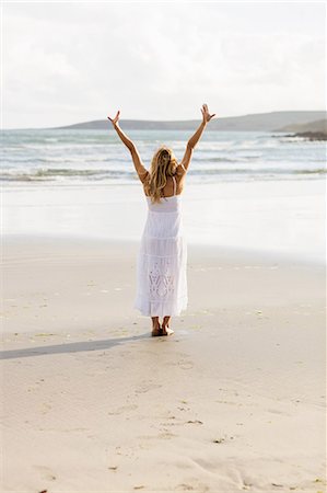 simsearch:6109-08435738,k - Beautiful blonde woman with arms outstretched in the coastline Photographie de stock - Premium Libres de Droits, Code: 6109-08435736