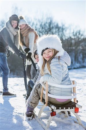 Portrait of family playing with sled on a beautiful snowy day Photographie de stock - Premium Libres de Droits, Code: 6109-08435861