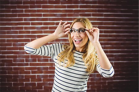 simsearch:400-08430017,k - Blonde woman posing with glasses on brick wall Stock Photo - Premium Royalty-Free, Code: 6109-08435805