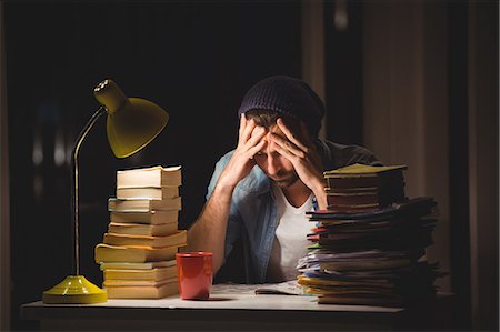 simsearch:6109-08581488,k - Thoughtful hipster with stacks of books Stock Photo - Premium Royalty-Free, Code: 6109-08581443