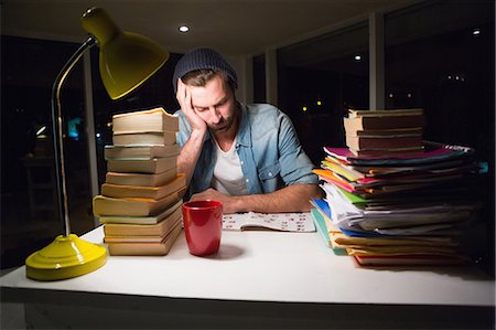 simsearch:6109-08581492,k - Thoughtful hipster with stacks of books Stock Photo - Premium Royalty-Free, Code: 6109-08581444