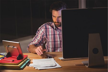 Hipster using computer and tablet computer Stock Photo - Premium Royalty-Free, Code: 6109-08581467