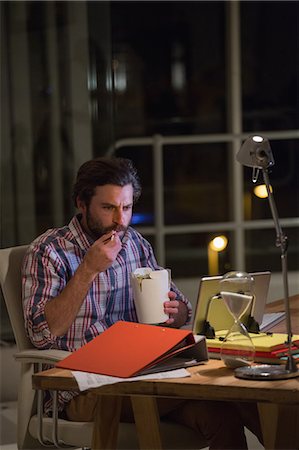 simsearch:6109-08581492,k - Hipster eating fast food front of computer Stock Photo - Premium Royalty-Free, Code: 6109-08581476
