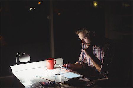 Hipster using a smartphone in darkness Stock Photo - Premium Royalty-Free, Code: 6109-08581486