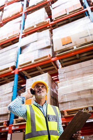 simsearch:6109-08581714,k - Smiling warehouse worker on a phone call Photographie de stock - Premium Libres de Droits, Code: 6109-08581496