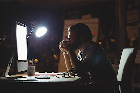 simsearch:6109-08581414,k - Businessman drinking coffee at night Stock Photo - Premium Royalty-Free, Code: 6109-08581401