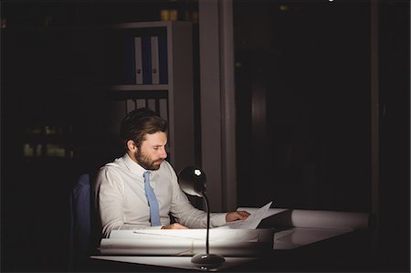 person working with papers - Overworked businessman working at night Stock Photo - Premium Royalty-Free, Code: 6109-08581425