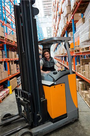 simsearch:400-04179277,k - Warehouse worker driving forklift Fotografie stock - Premium Royalty-Free, Codice: 6109-08581563