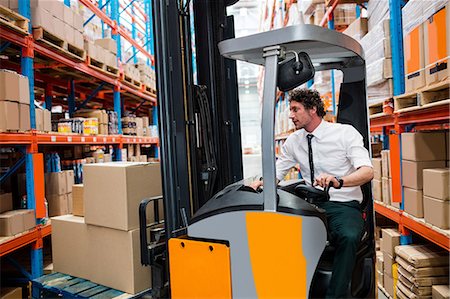 supplies (stock of essential items needed to sustain life) - Warehouse manager using a forklift Foto de stock - Sin royalties Premium, Código: 6109-08581584