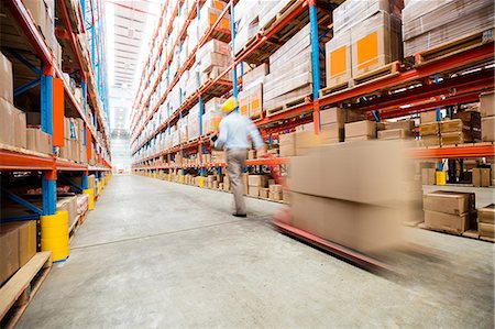 distribution warehouse - Warehouse worker crossing an aisle Stock Photo - Premium Royalty-Free, Code: 6109-08581517