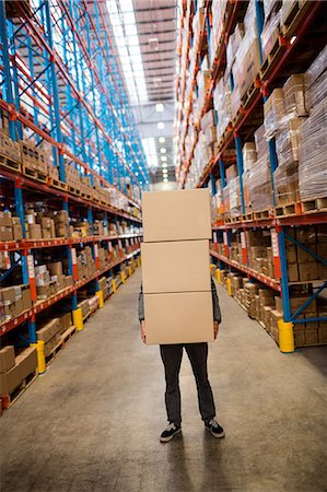 simsearch:6109-08690241,k - Obscured worker carrying boxes Stock Photo - Premium Royalty-Free, Code: 6109-08581519