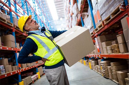 Worker with backache while carrying box Stock Photo - Premium Royalty-Free, Code: 6109-08581520