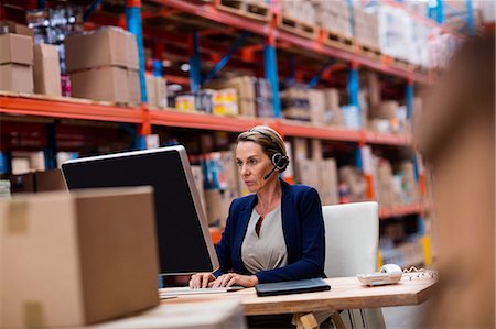 simsearch:400-04035704,k - Warehouse manager working on her computer desk Fotografie stock - Premium Royalty-Free, Codice: 6109-08581642