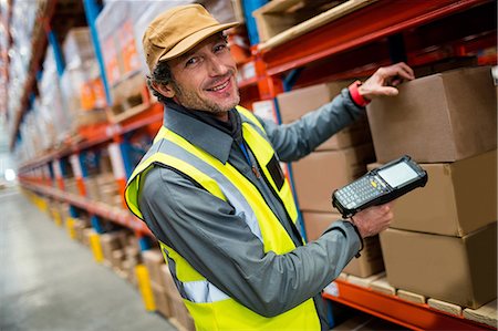 Warehouse worker using hand scanner Stock Photo - Premium Royalty-Free, Code: 6109-08581686