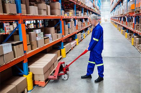 simsearch:600-07206657,k - Worker pushing trolley with boxes Fotografie stock - Premium Royalty-Free, Codice: 6109-08581695