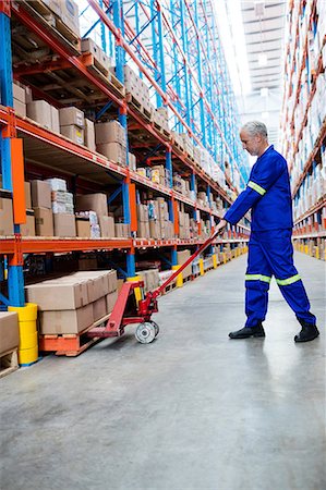 simsearch:633-03444763,k - Worker pushing trolley with boxes Photographie de stock - Premium Libres de Droits, Code: 6109-08581696