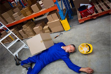 High angle view of unconscious worker lying on the floor Stock Photo - Premium Royalty-Free, Code: 6109-08581604