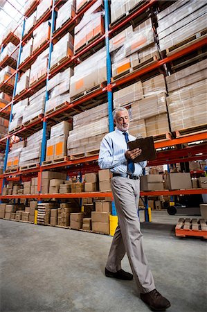 Low angle view of warehouse manager taking notes Stock Photo - Premium Royalty-Free, Code: 6109-08581635