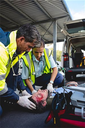simsearch:6109-08689805,k - Ambulancemen healing injured man Foto de stock - Sin royalties Premium, Código: 6109-08581777