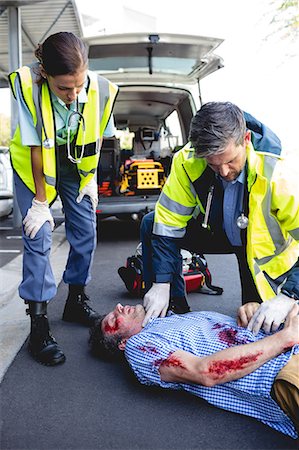 simsearch:6109-08689784,k - Ambulanceman healing injured man Photographie de stock - Premium Libres de Droits, Code: 6109-08581774