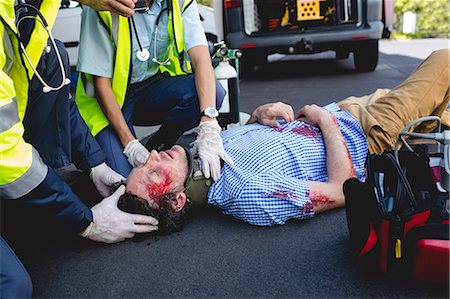 simsearch:6109-08689805,k - Ambulancemen healing injured man Foto de stock - Sin royalties Premium, Código: 6109-08581775