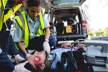 simsearch:6109-08689784,k - Ambulancemen healing injured man Photographie de stock - Premium Libres de Droits, Code: 6109-08581776
