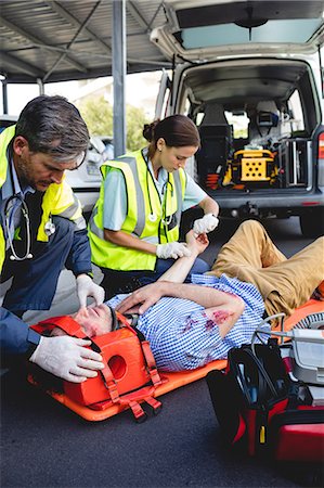 simsearch:6109-08689805,k - Ambulancemen healing injured man Foto de stock - Sin royalties Premium, Código: 6109-08581782