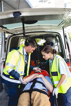 simsearch:6109-08581798,k - Ambulancemen carrying injured man on a stretcher Stock Photo - Premium Royalty-Free, Code: 6109-08581793