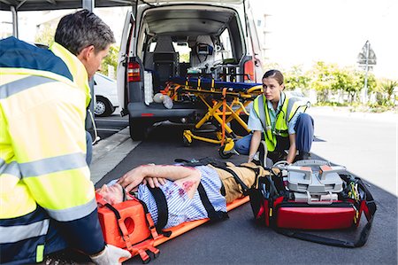 simsearch:6109-08689784,k - Ambulancemen carrying injured man on a stretcher Photographie de stock - Premium Libres de Droits, Code: 6109-08581790